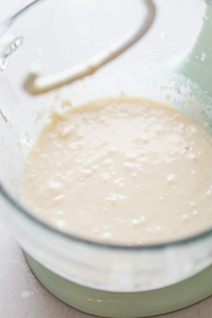 A glass mixing bowl holding the wet ingredients for the recipe.