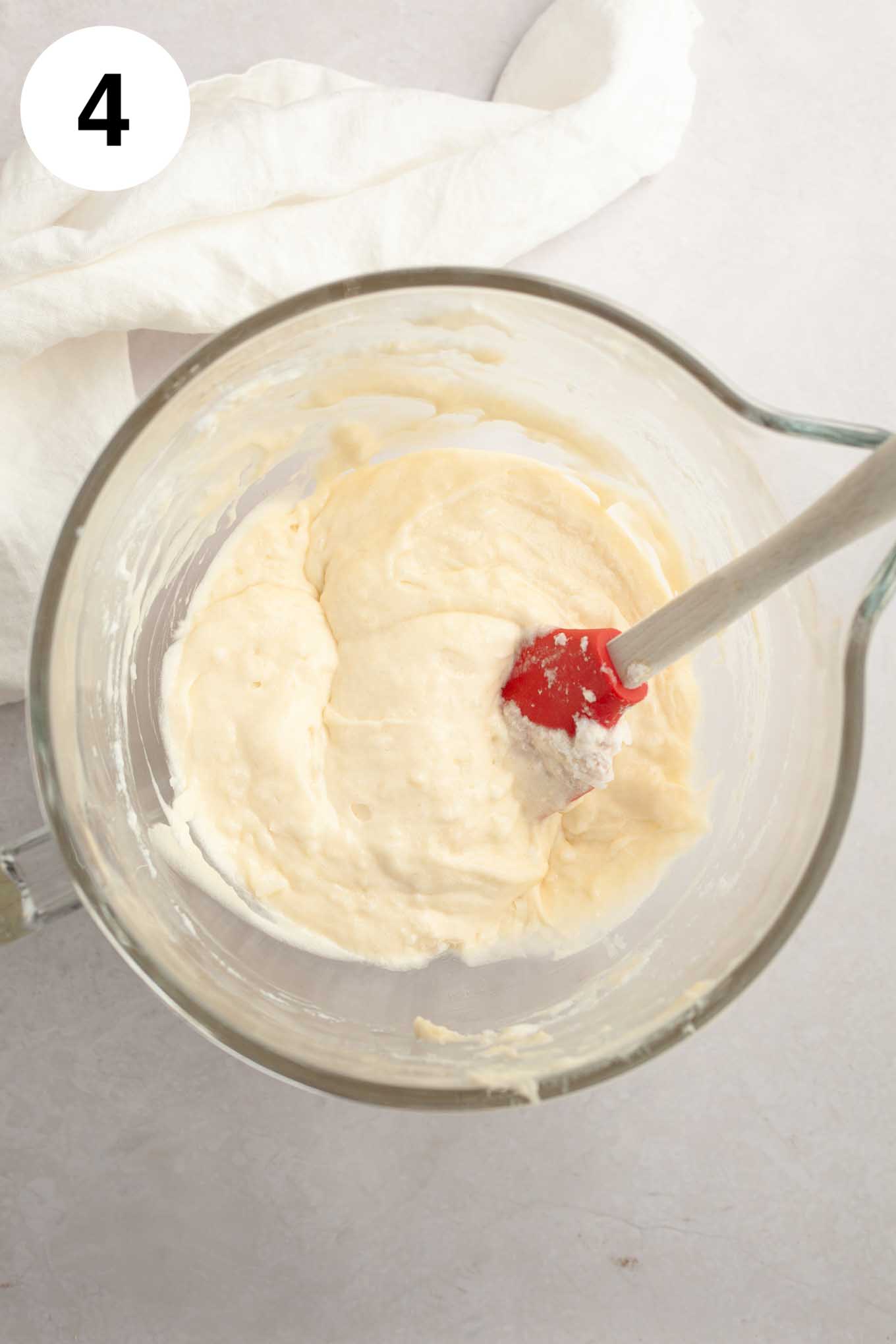 An overhead view of the cupcake batter in a glass mixing bowl.