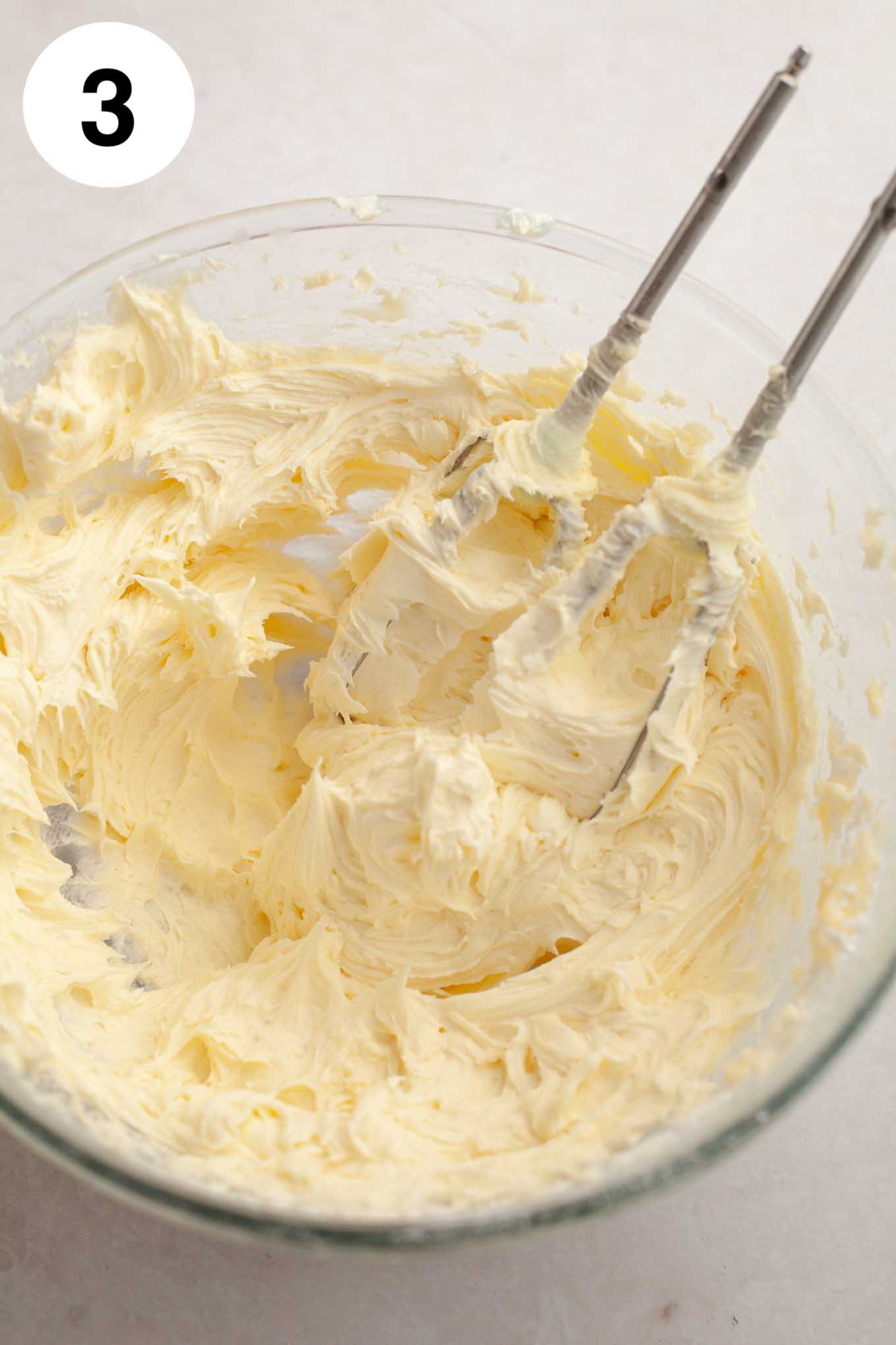 Coconut frosting mixed together in a glass mixing bowl.