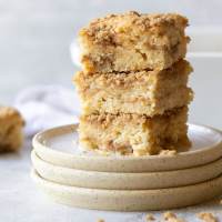 A stack of coffee cake pieces showing the cake and streusel layers.