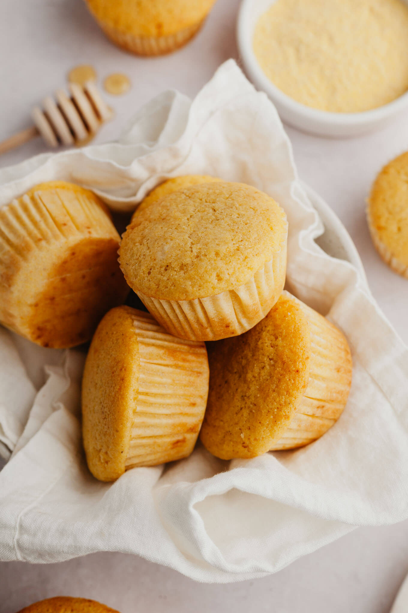 A pile of cornbread muffins in a towel-lined serving bowl. 