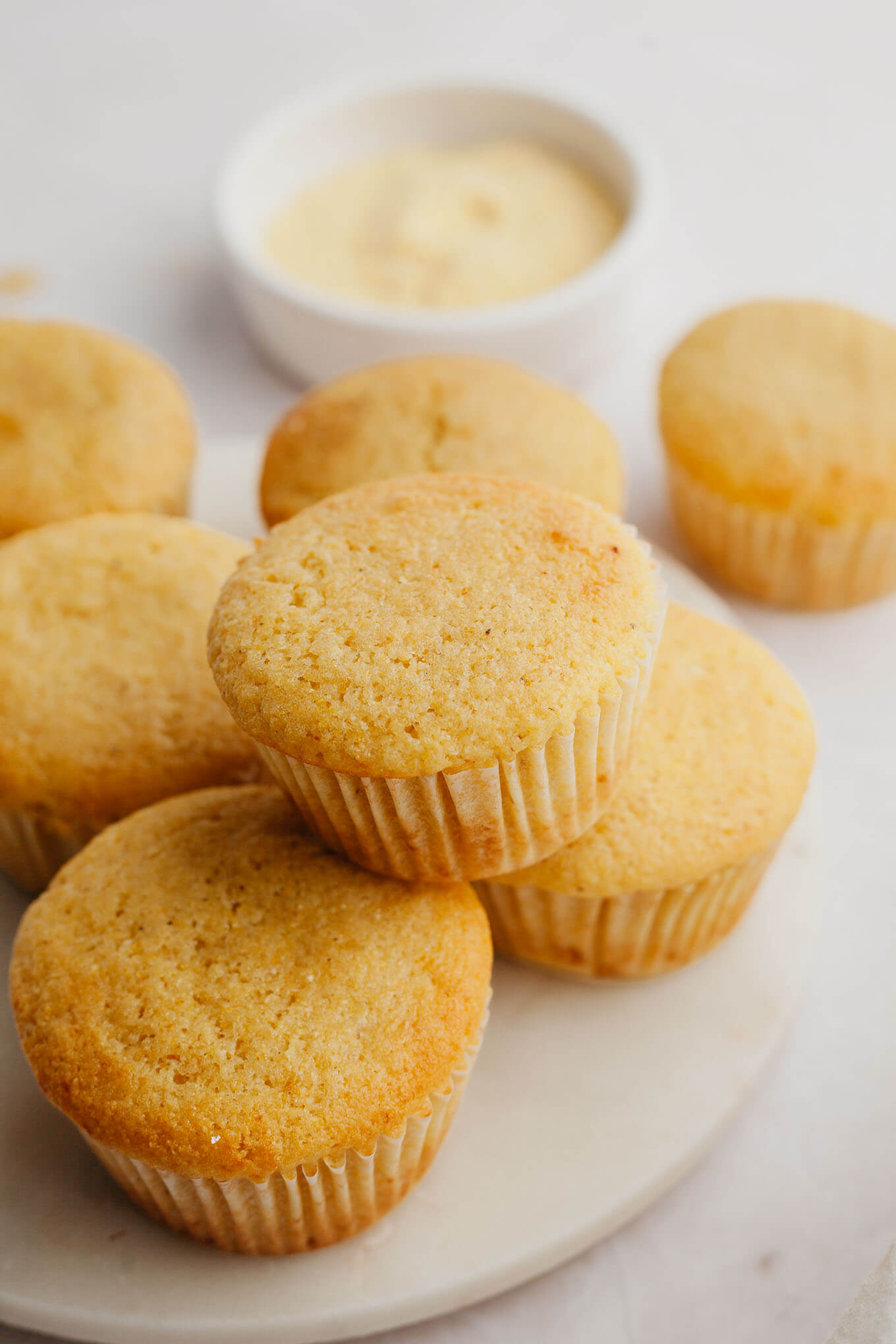 A marble serving platter with several cornbread muffins sitting on top.