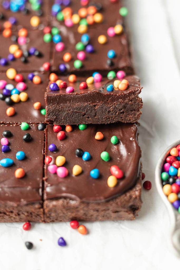 Two rows of sliced homemade Cosmic Brownies, with one brownie tipped up onto the others. 