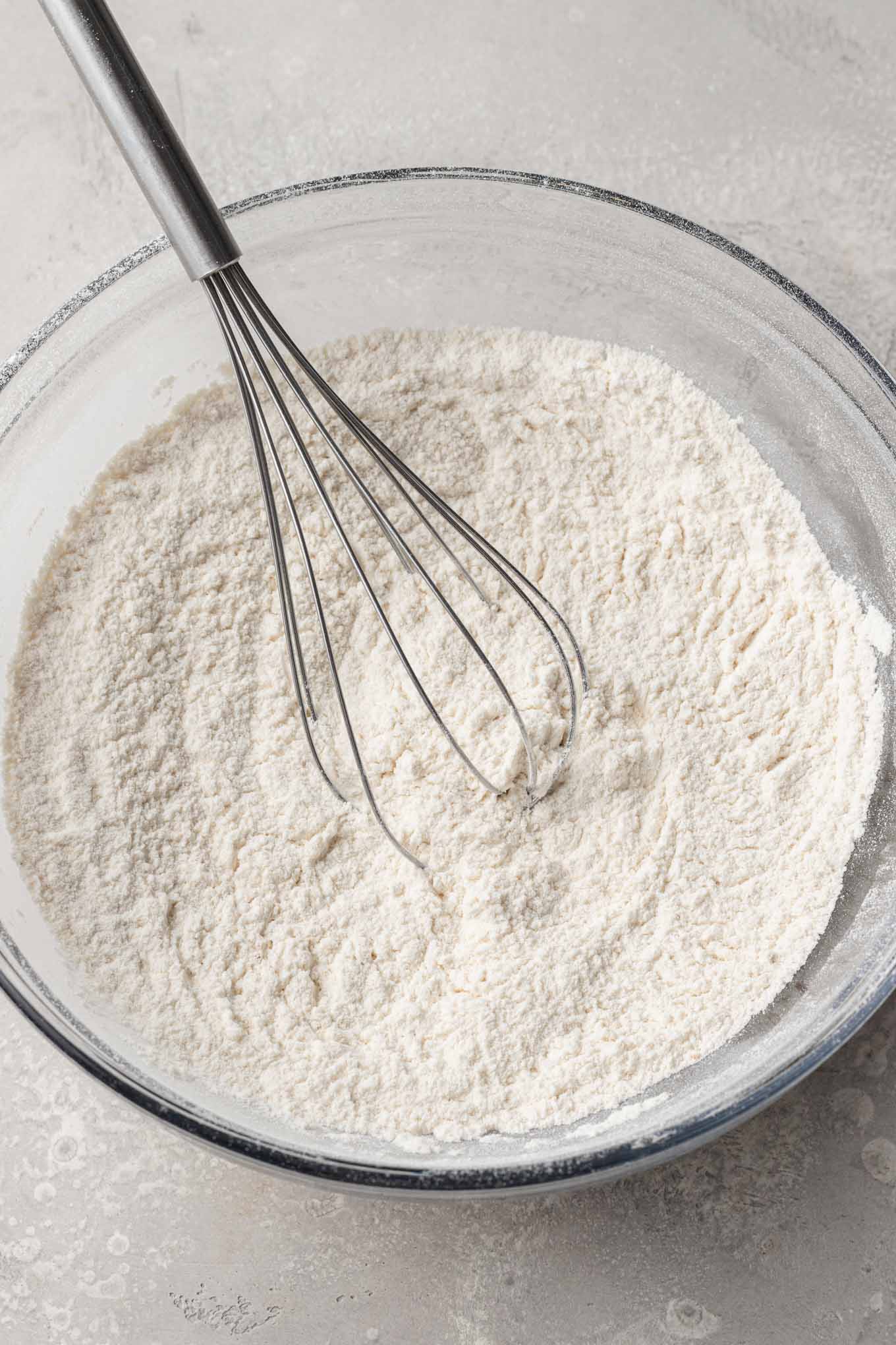 An overhead view of flour and spices combined in a mixing bowl. 