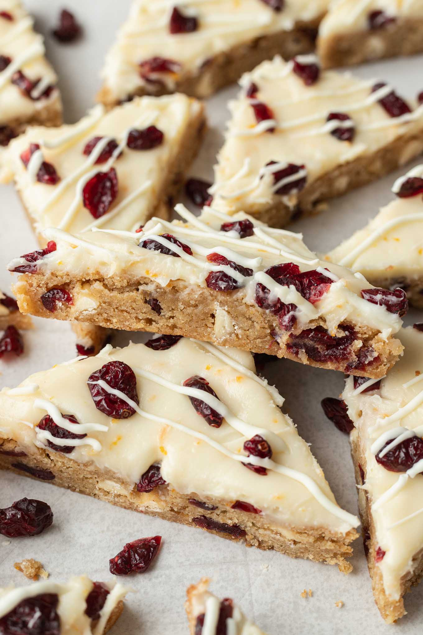 A cranberry bliss bar turned on its side and resting on another bar. 