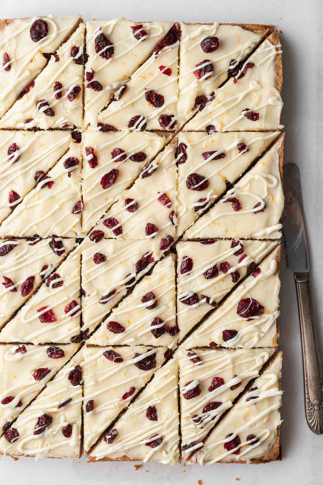 An overhead view of copycat cranberry bliss bars, sliced into triangles. 