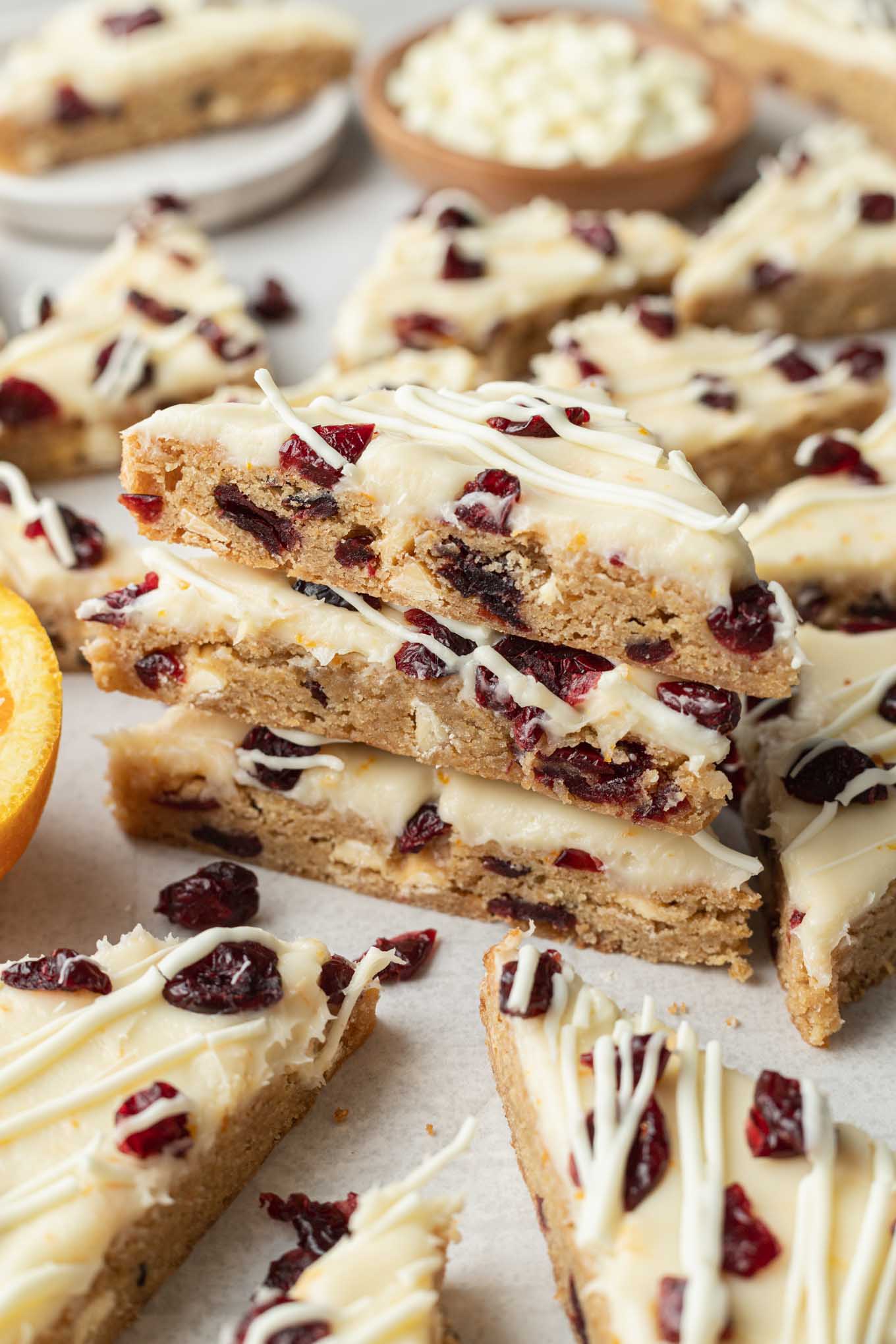 A stack of three cranberry bliss bars, surrounded by additional bars. 