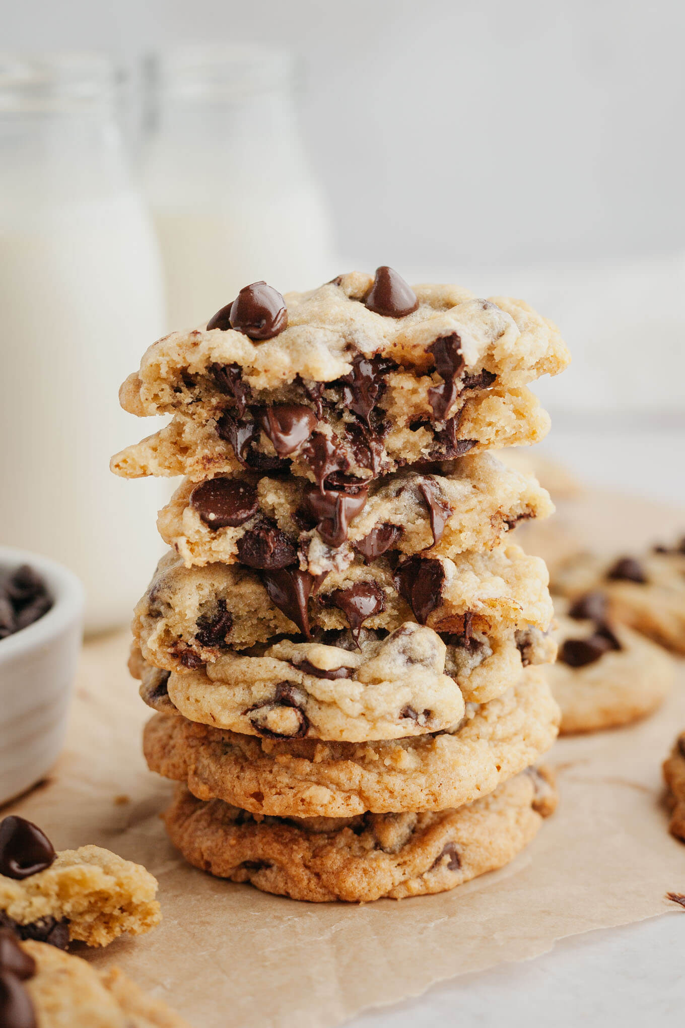 A stack of gooey cream cheese chocolate chip cookies on parchment paper. 