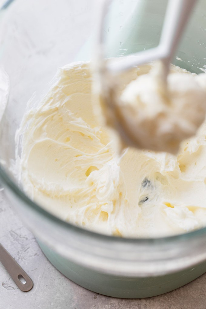 A glass mixing bowl showing frosting being mixed up.