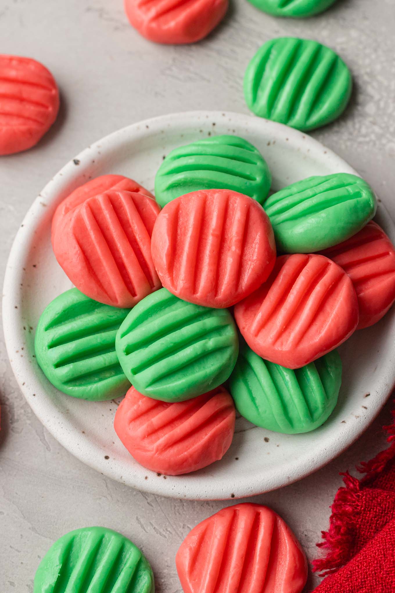 An overhead view of a plate piled high with homemade cream cheese mints. 