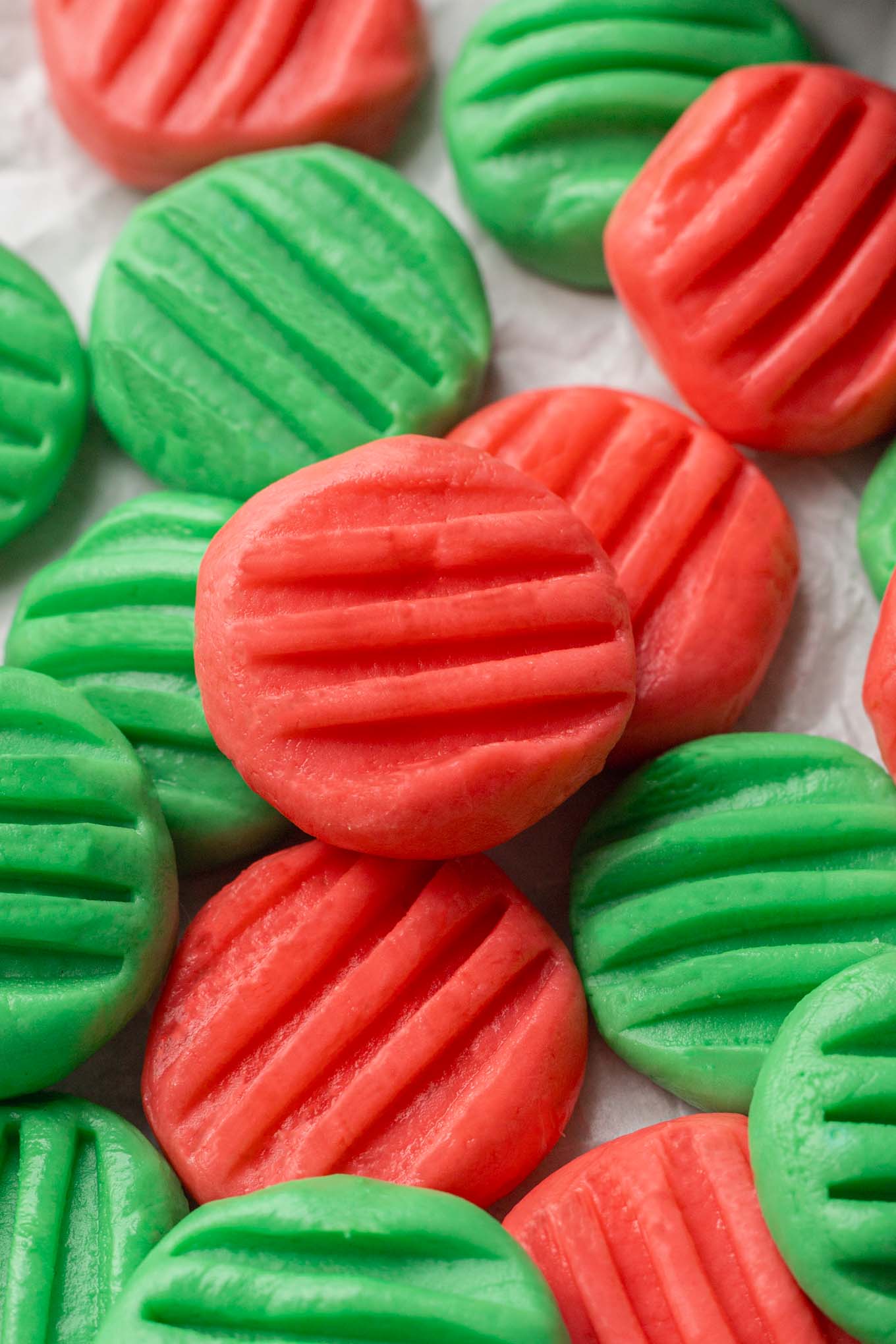 A close-up view of homemade wedding mints made with cream cheese that have been dyed red and green. 