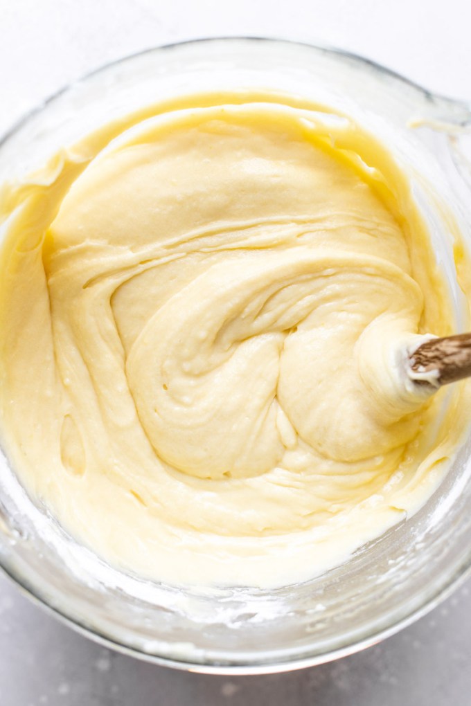 An overhead view of the finished pound cake batter in a glass mixing bowl.