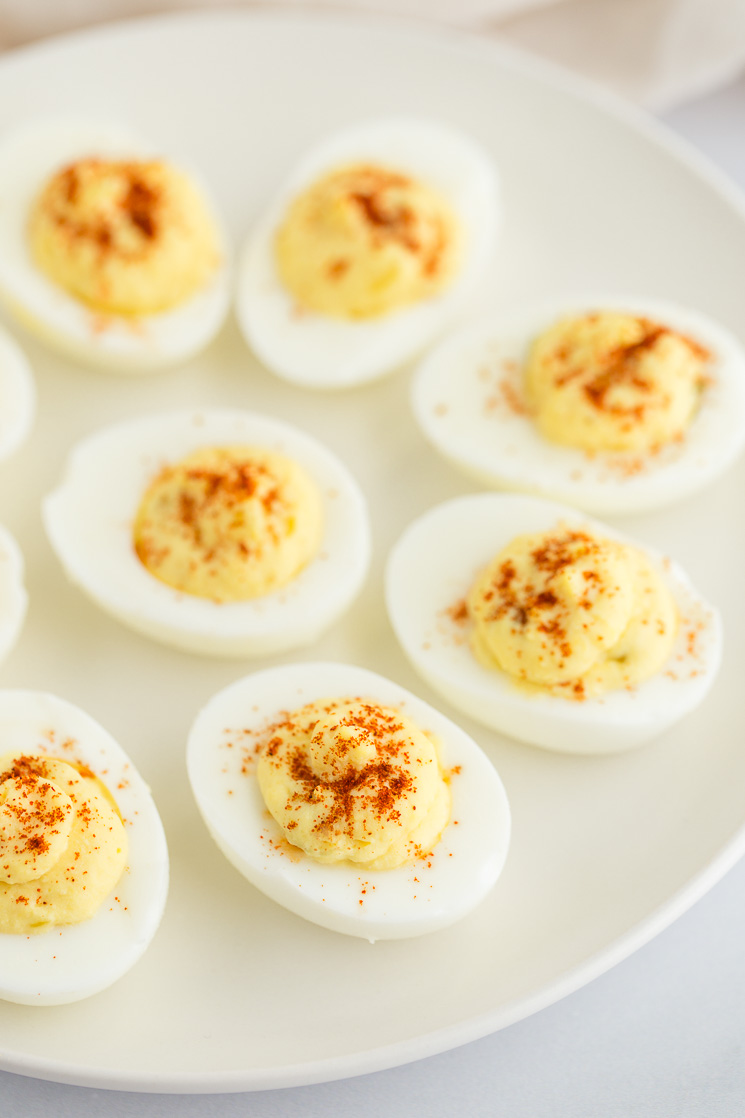 Deviled eggs sitting on top of a white matte plate.