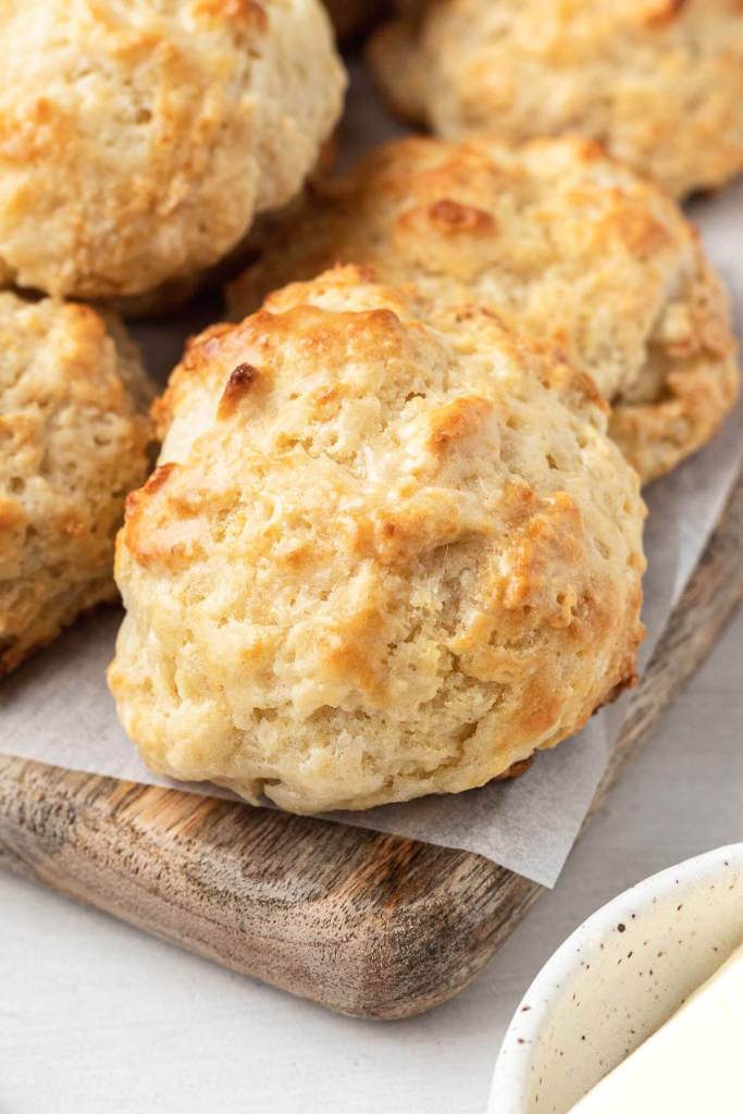 Homemade drop biscuits on a wooden serving board. 