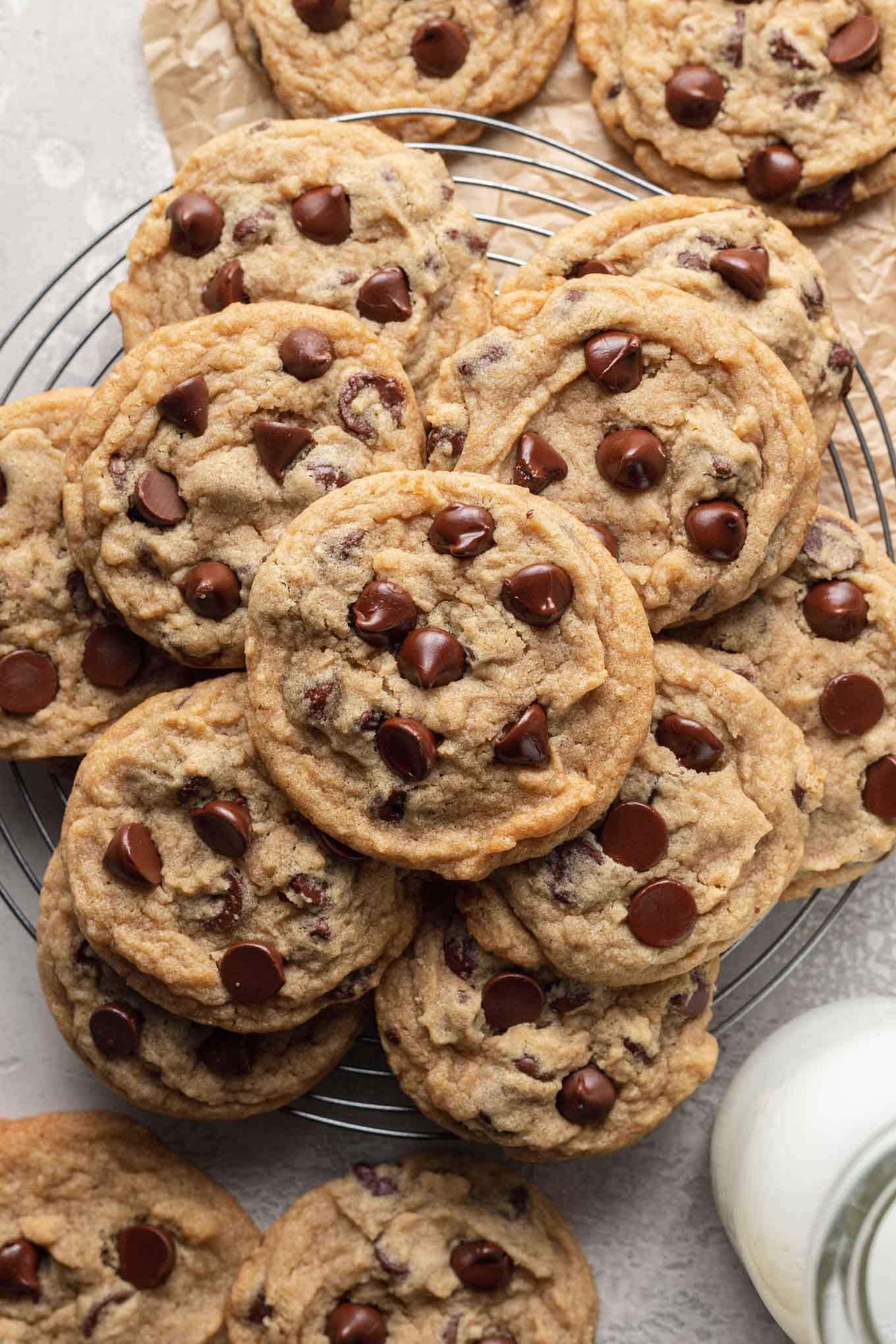 An overhead view of egg-free chocolate chip cookies stacked on a wire cooling rack. 