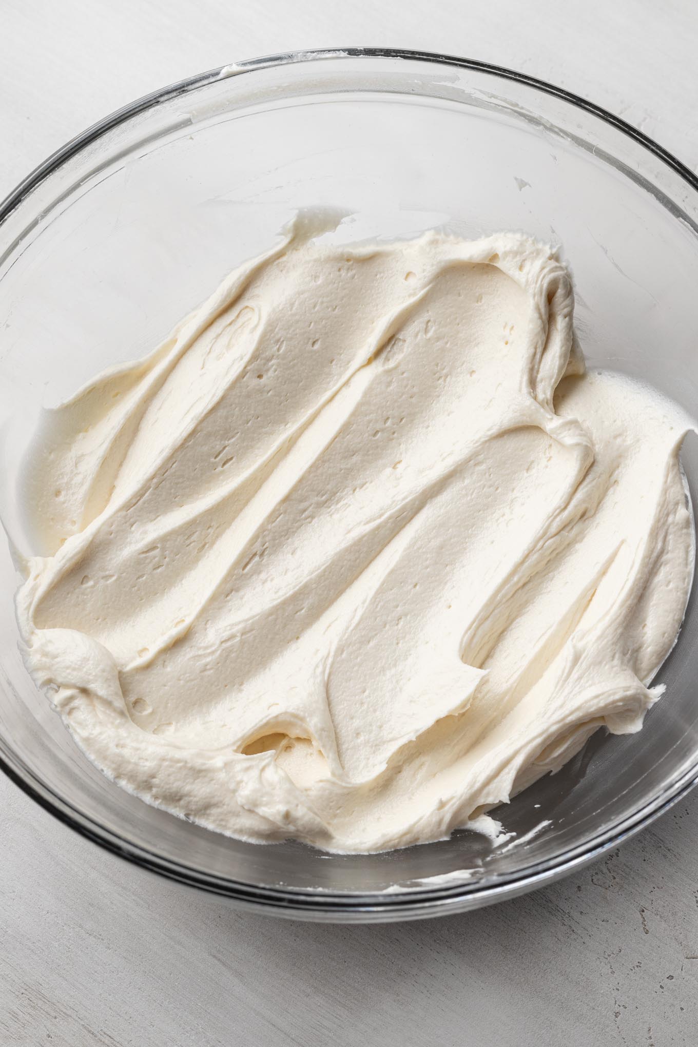 Whipped ermine frosting in a glass mixing bowl.