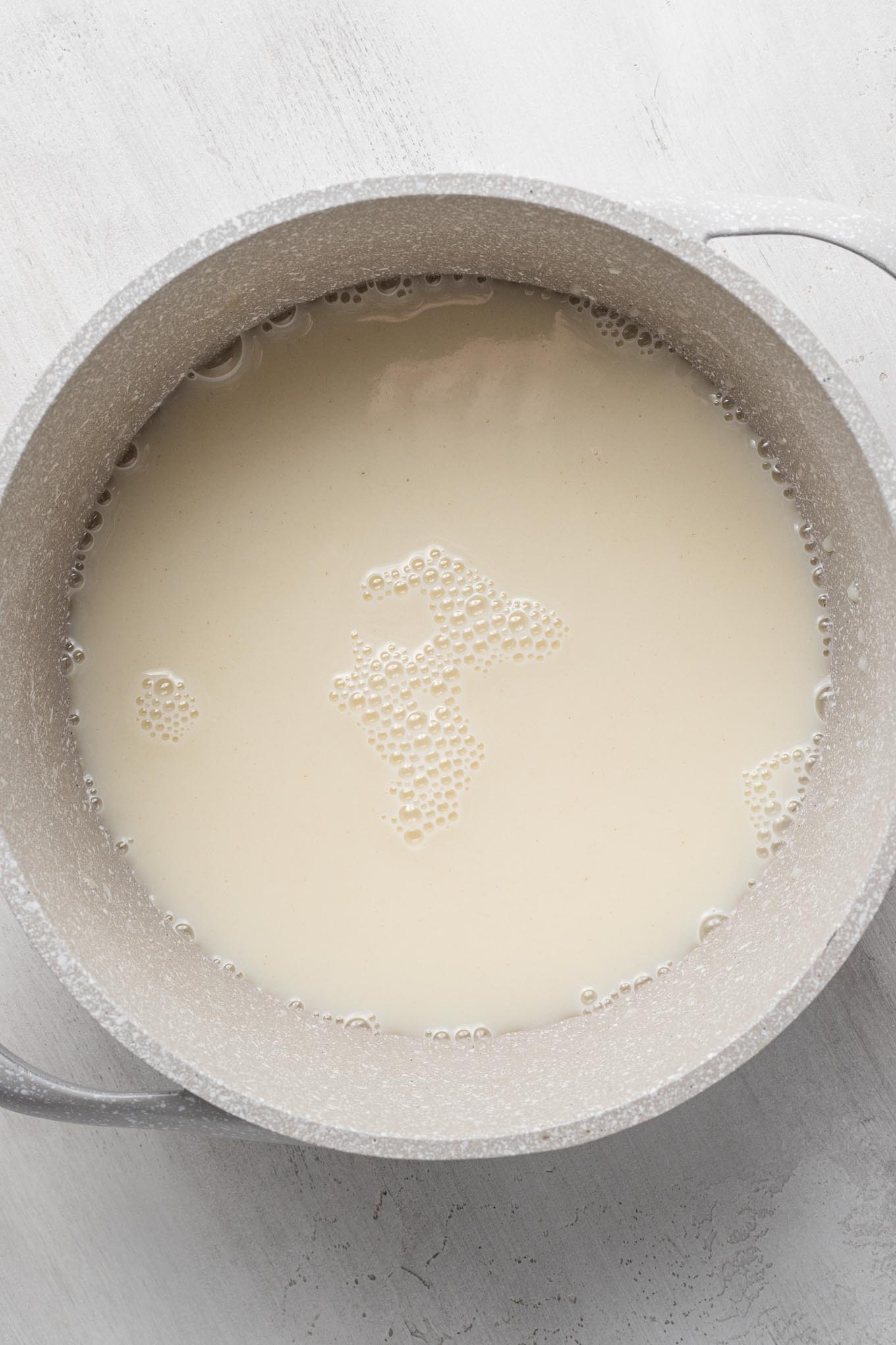 An uncooked mixture of flour, milk, and sugar in a saucepan.