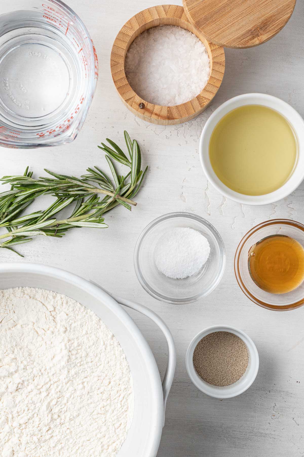 An overhead view of the ingredients needed to make focaccia bread with rosemary. 