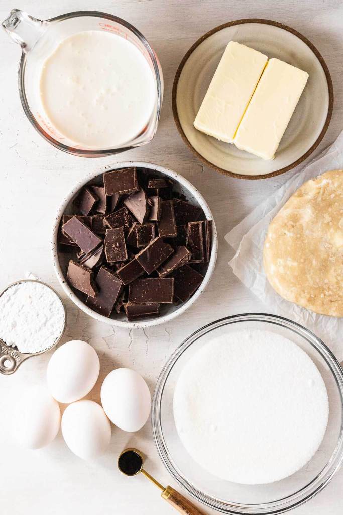 An overhead view of the ingredients needed to make a traditional French silk chocolate pie. 