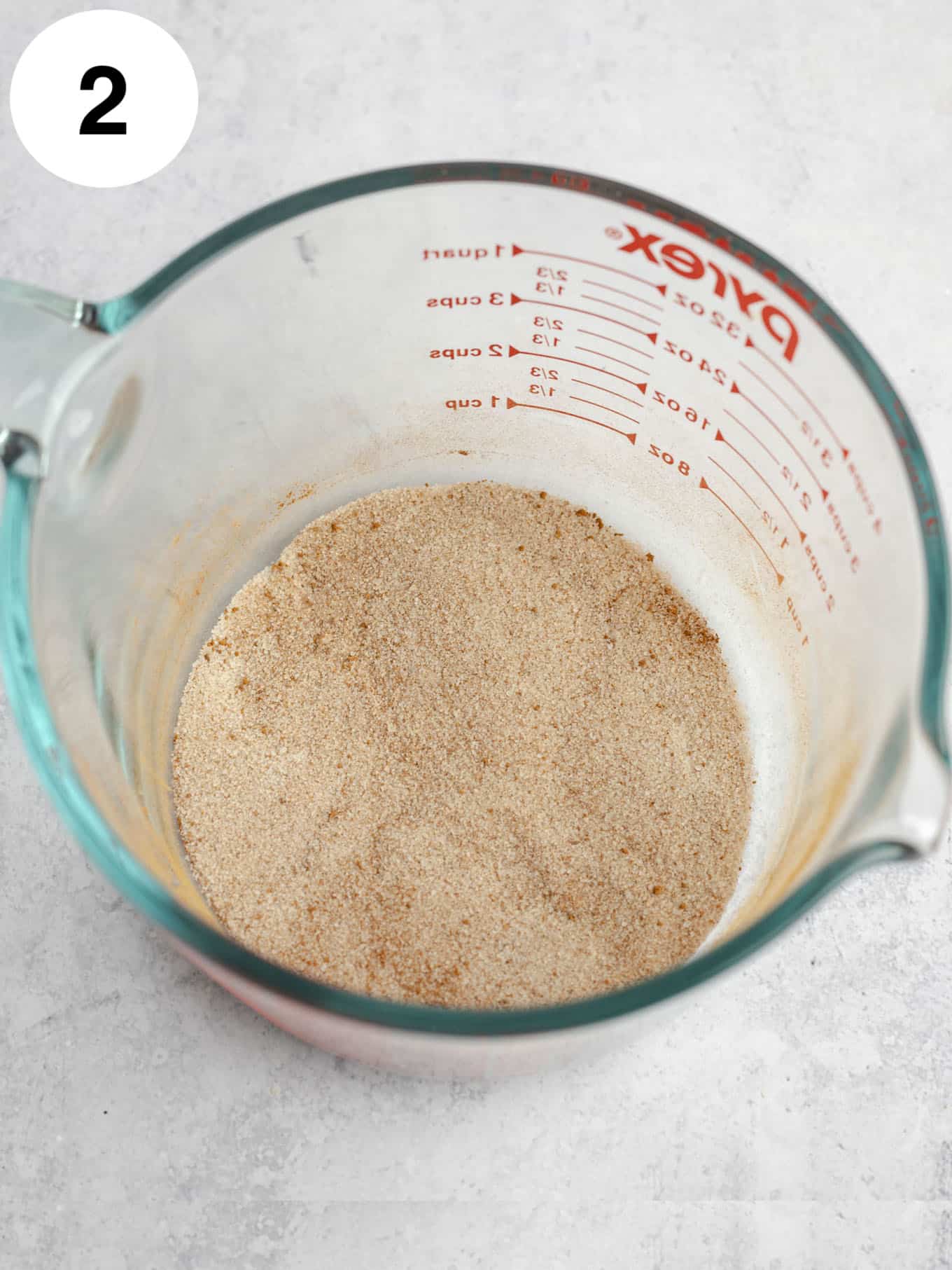 Sugar, cinnamon, and nutmeg whisked together in a large measuring cup.