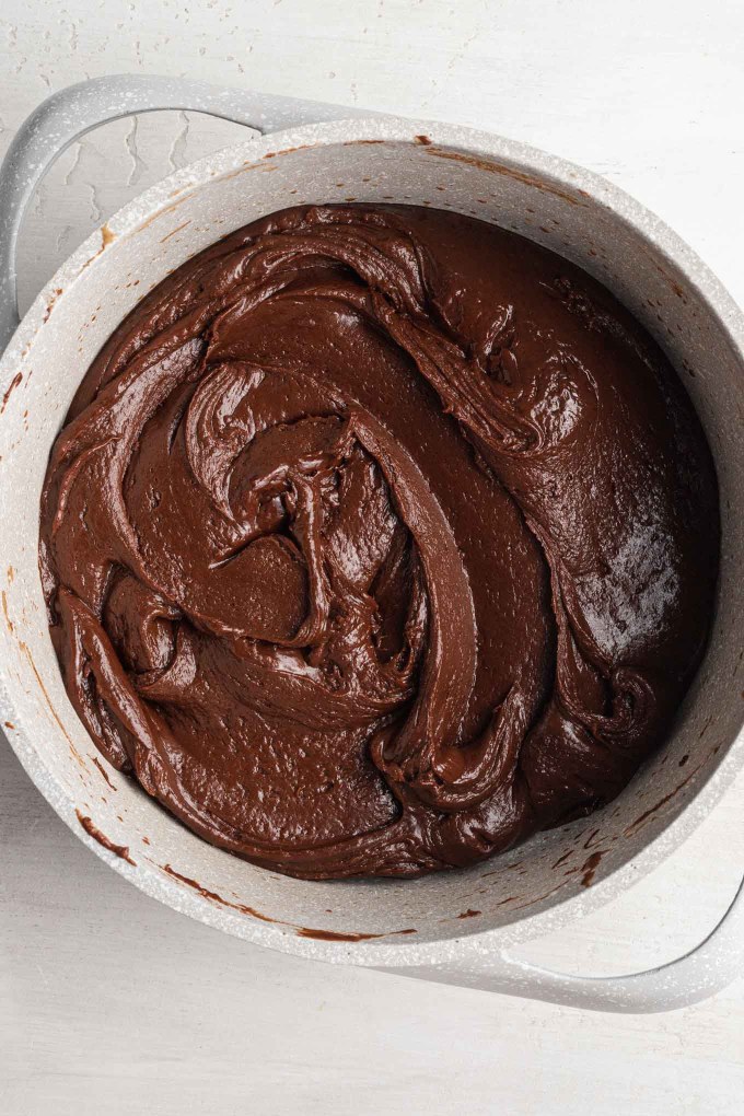 An overhead view of melted chocolate fudge in a saucepan.