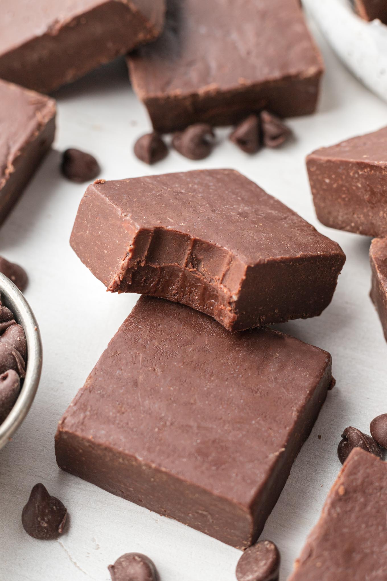 A slice of fudge with a bite missing, resting atop another slice of fudge. 