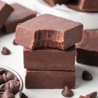 Three pieces of fudge stacked on top of each other. The top piece has a bite taken out of it.