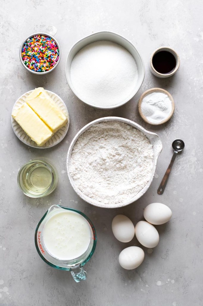 An overhead view of the ingredients needed to make funfetti cake from scratch. 