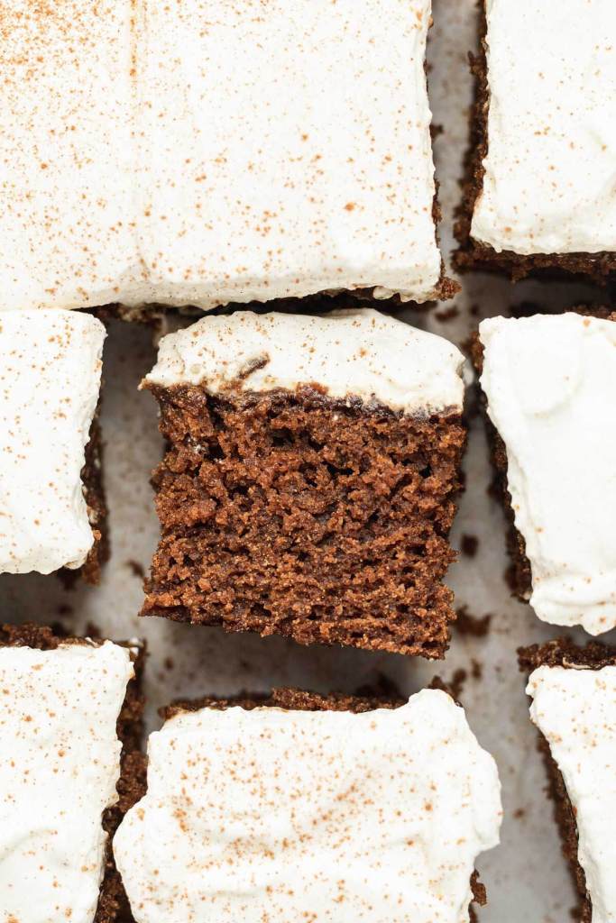 An overhead view of slices of gingerbread cake. One slice is turned on its side. 