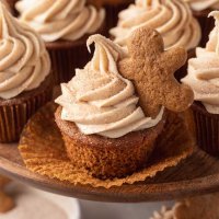 Several gingerbread cupcakes on a wooden cake stand.