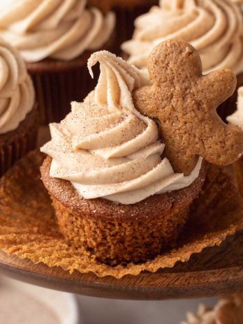 Several gingerbread cupcakes on a wooden cake stand.