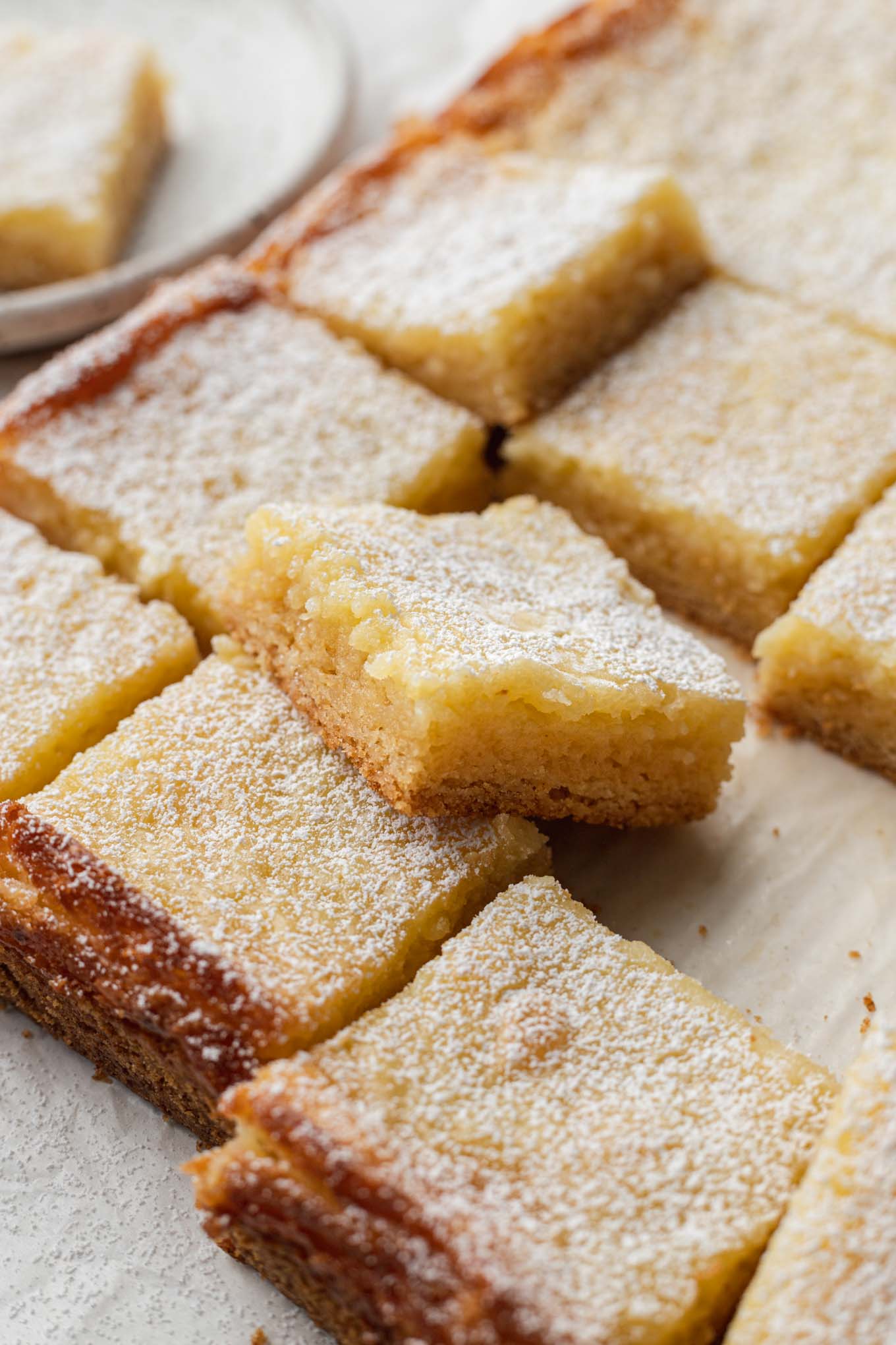 Slices of homemade gooey butter cake dusted with powdered sugar. 