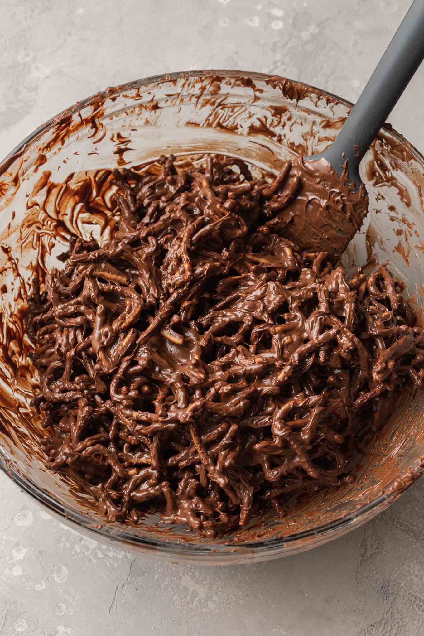 An overhead view the melted chocolate peanut butter mixture with chow mein noodles mixed in.