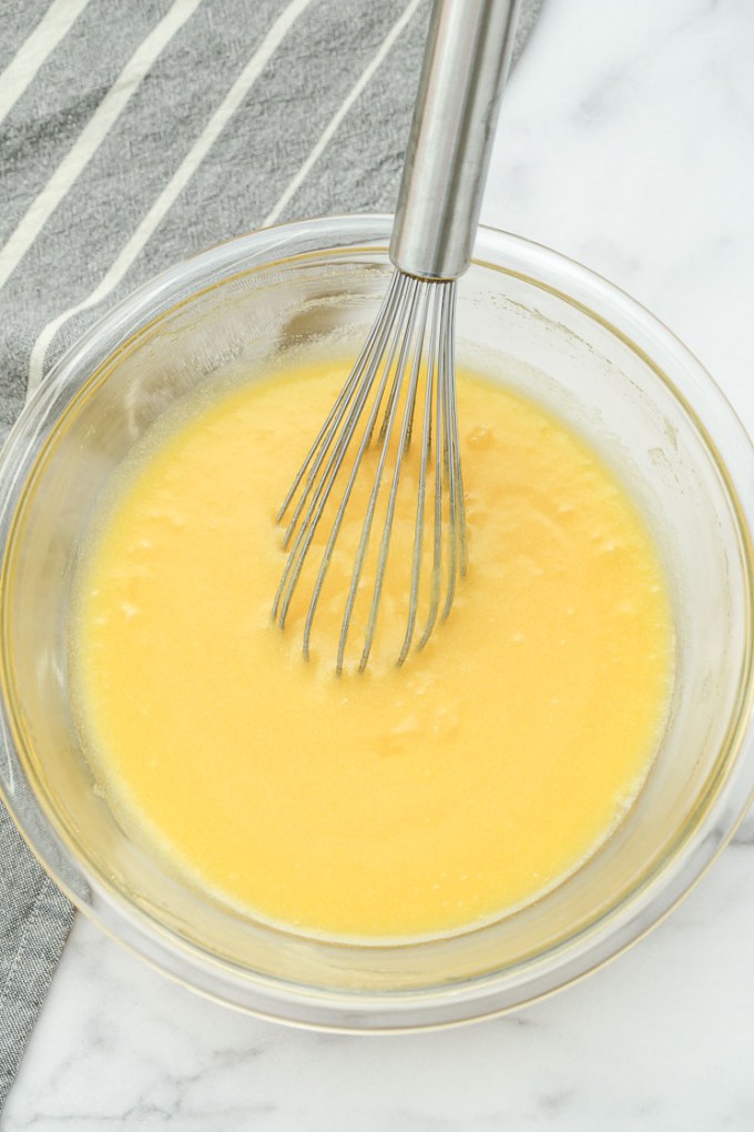 A clear bowl filled with the wet ingredients for brownies.