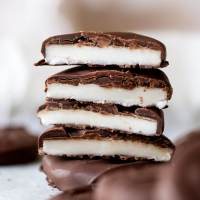 A stack of homemade peppermint patties cut in half to show the layers.