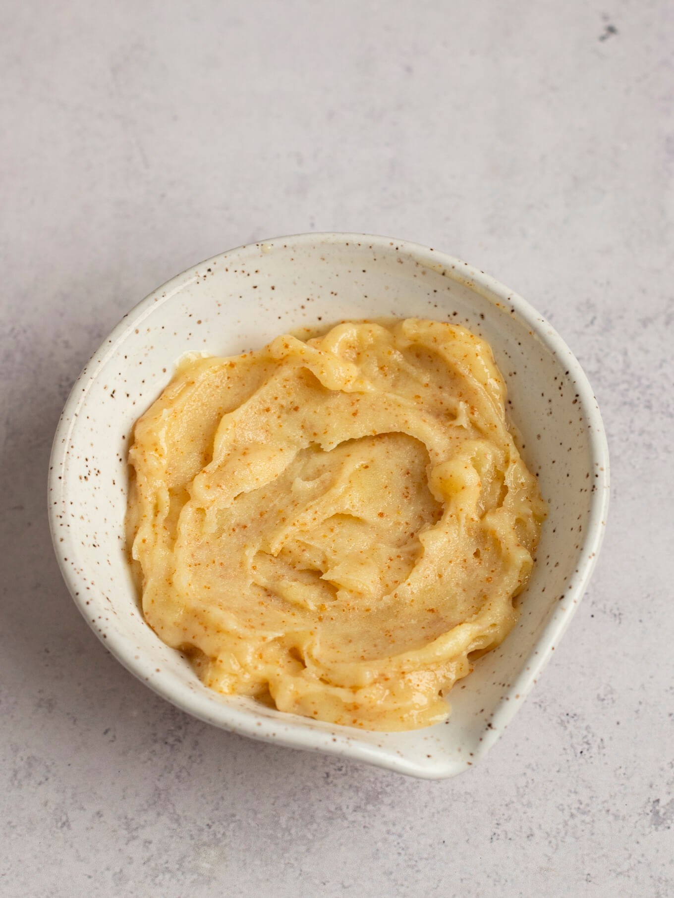 A bowl filled with softened browned butter.