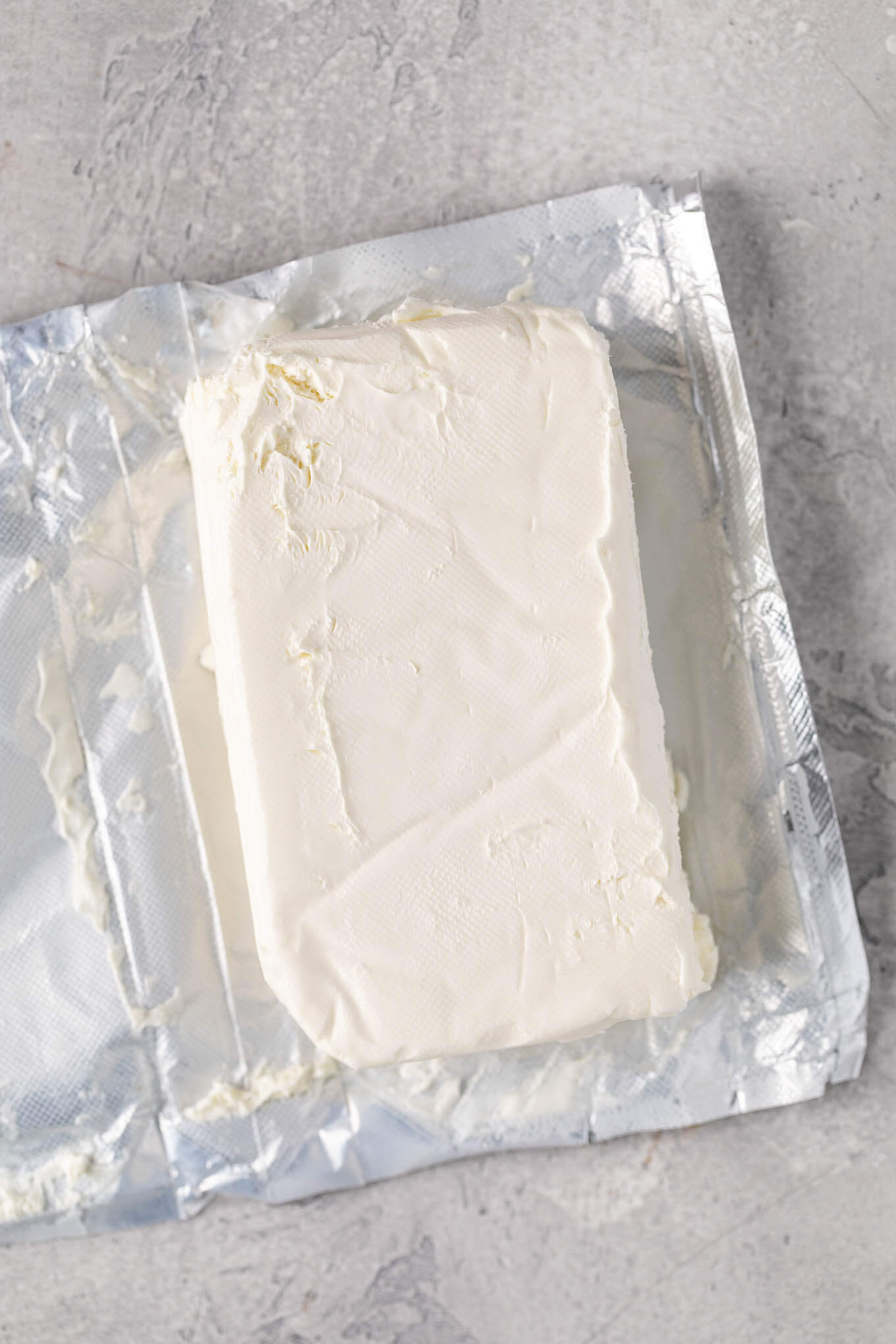 An overhead view of an opened package of cream cheese.