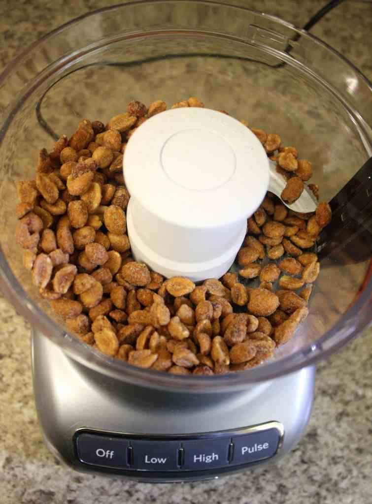 A food processor full of honey roasted peanuts. 