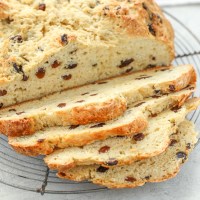 A sliced loaf of Irish Soda Bread on top of an antique round cooling rack.