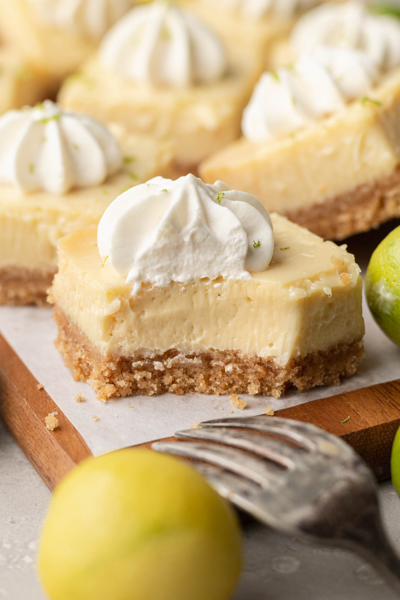 A close-up view of a key lime bar with a bite missing, showing how creamy its filling is. 