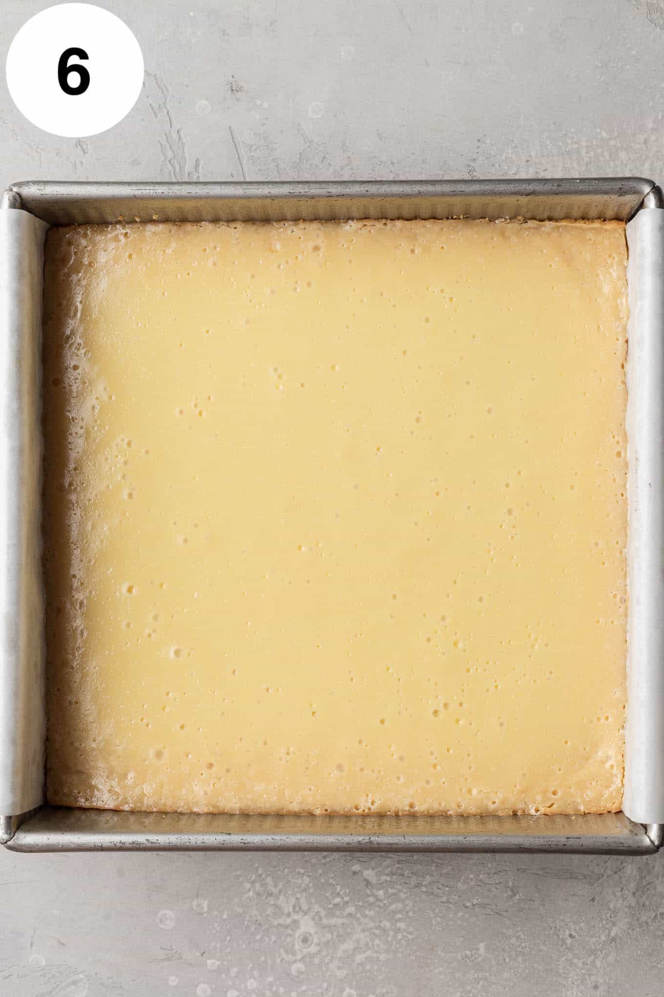 An overhead view of baked key lime bars in a square baking dish. 