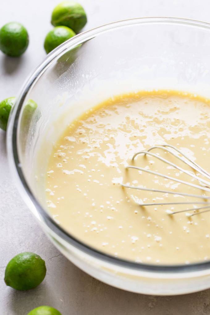 Key lime pie filling in a large glass mixing bowl.