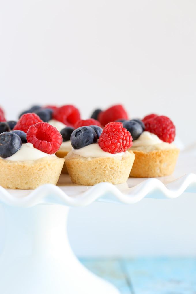 Sugar cookie cups filled with a no-bake lemon cream cheese filling and topped with fresh berries. These Lemon Berry Cheesecake Sugar Cookie Cups make the perfect summer dessert!