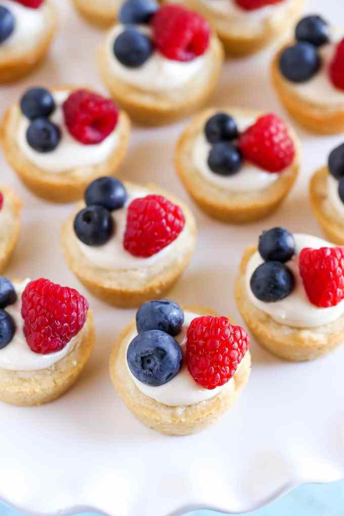 Sugar cookie cups filled with a no-bake lemon cream cheese filling and topped with fresh berries. These Lemon Berry Cheesecake Sugar Cookie Cups make the perfect summer dessert!