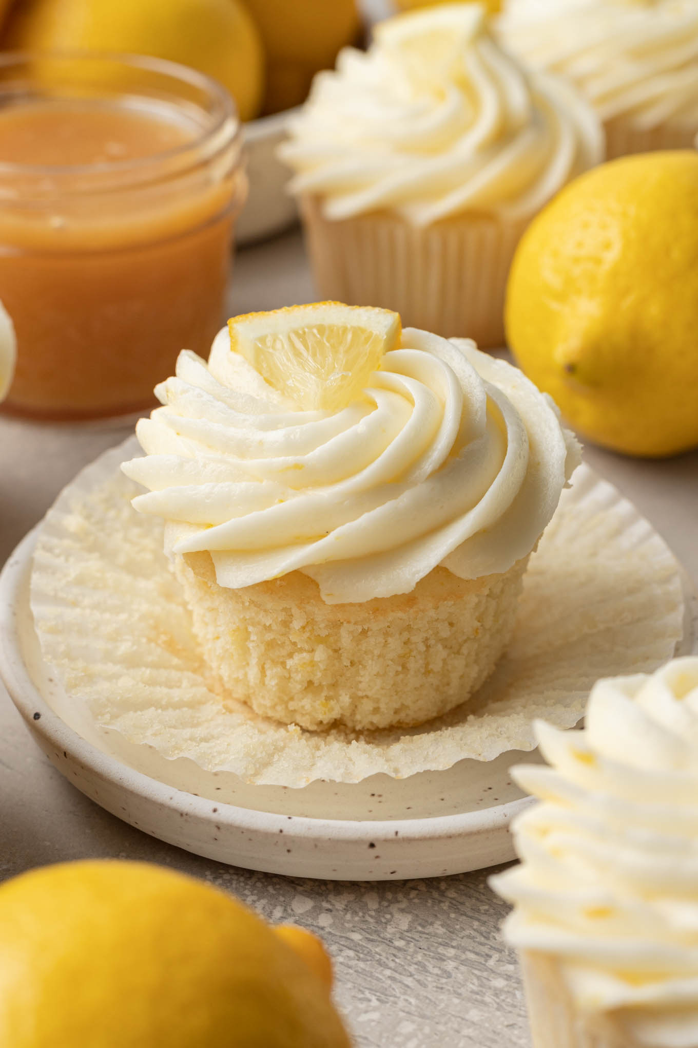 A close up view of a lemon filled cupcake with the cupcake liner pulled down. 