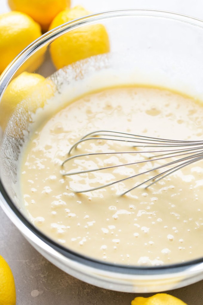 The pie filling being mixed up with a metal whisk in a glass mixing bowl.