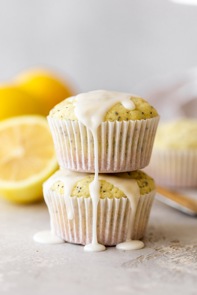 Two muffins stacked with lemon glaze on top and running down the sides.