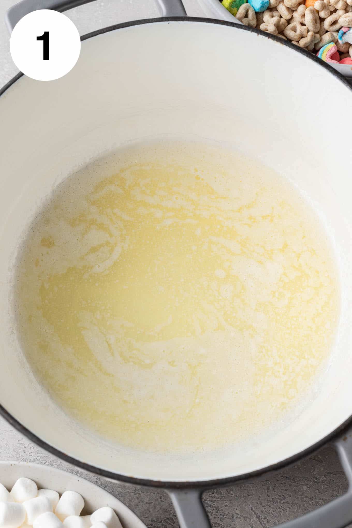 An overhead view of melted butter in a large saucepan. 