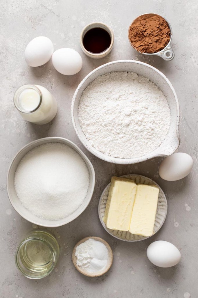 An overhead view of the ingredients needed to make a chocolate vanilla marble cake. 