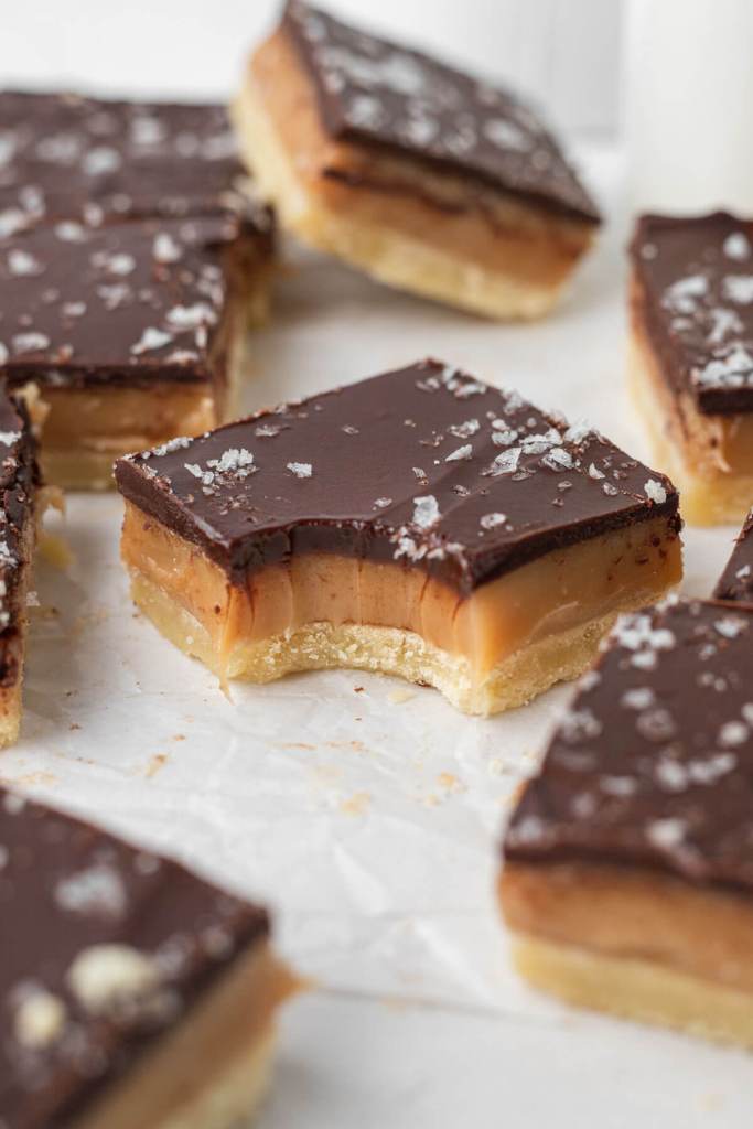 Millionaire bars on parchment paper. The bar in the middle has a bite missing. 